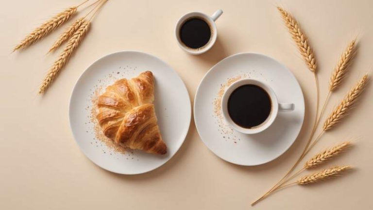 A golden croissant on a white plate with wheat stalks and a steaming cup of coffee symbolizing World Croissant Day in Australia.