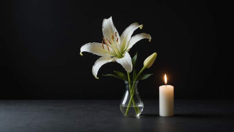 A delicate white lily and a glowing candle symbolizing remembrance for mothers who have lost children in Australia